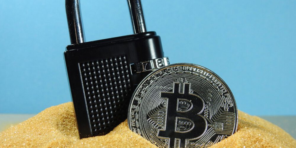 Padlock And Bitcoin On A Pile Of Sand