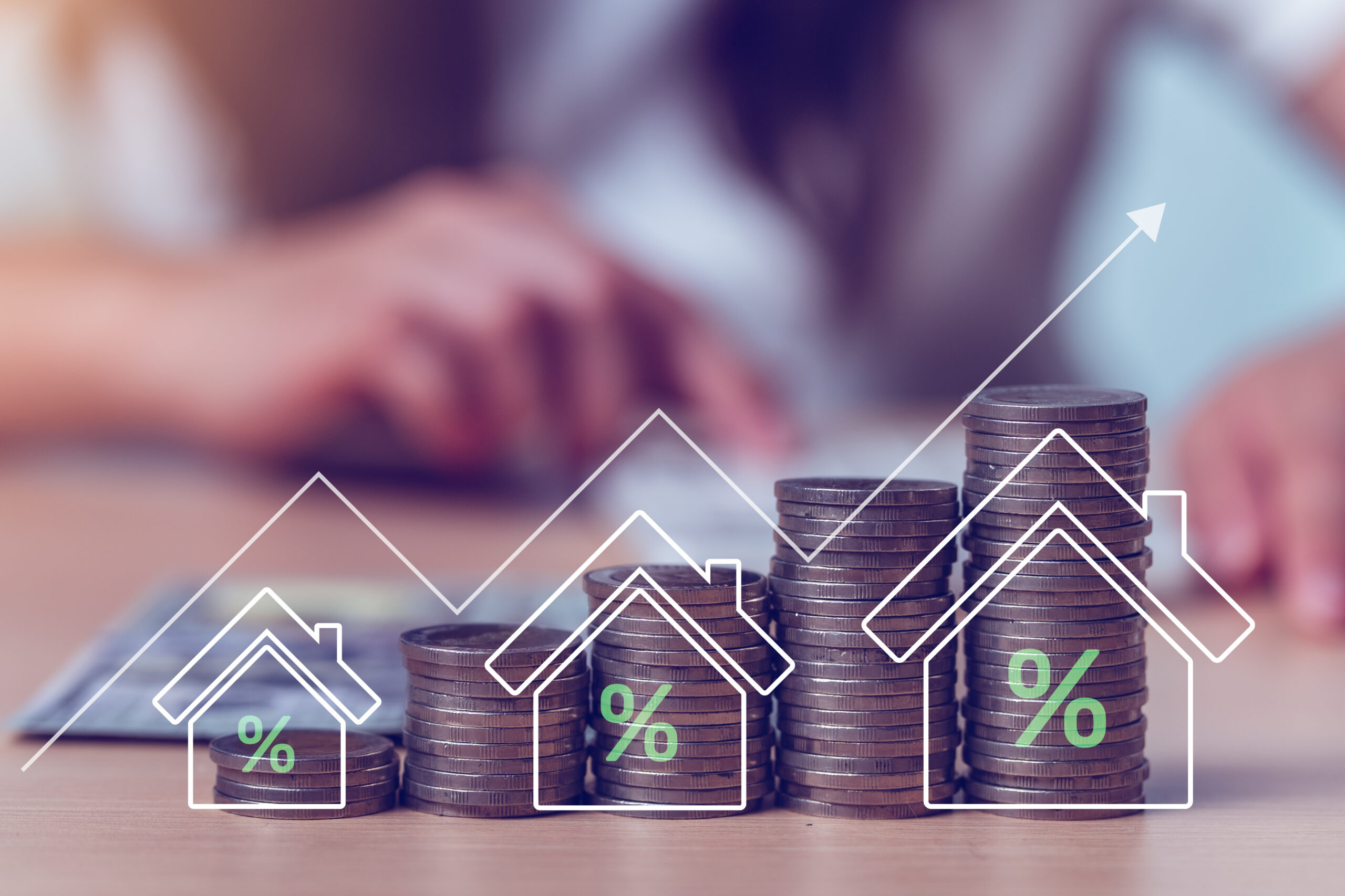 Ascending stacks of coins with percentage symbols and an upward arrow representing rising interest rates